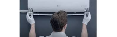 Technician installing a wall-mounted indoor air conditioner