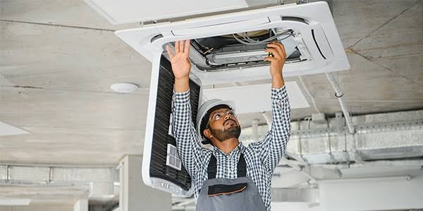 Technician inspecting a ceiling air cassette and filter