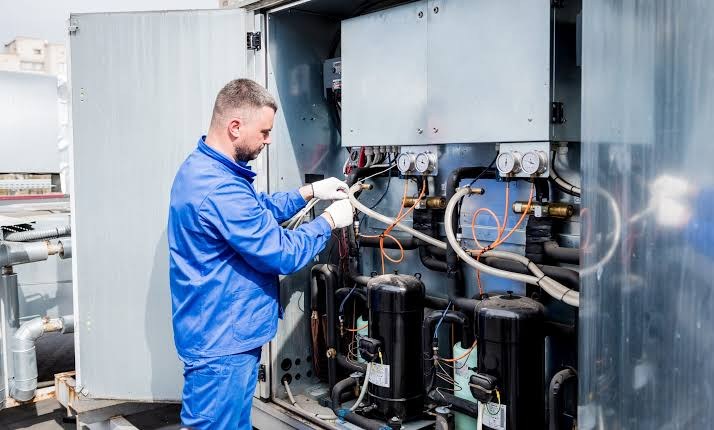 Technician working on mechanical HVAC equipment during a system installation